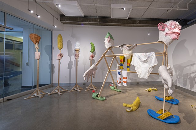 Anthropomorphic clothes hanging device, with fisted forest of food on sticks

Photo credit:  Jaime Alvarez