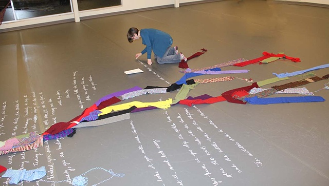Transcribing the poem "Unraveling" onto the gallery floor with chalk.